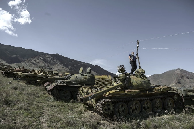 Командир батальона Валерий Вощевоз осматривает разбитую советскую военную технику на перевале Саланг в Афганистане.