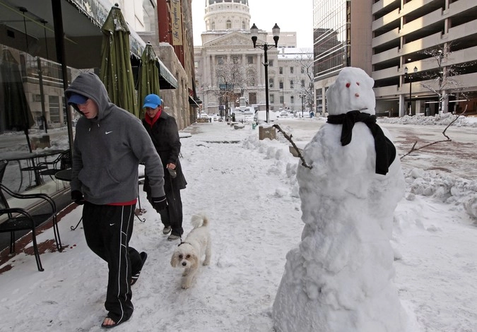 Пара выгуливает  свою собаку  возле здания Капитолия в Индианаполисе. Индиана .  