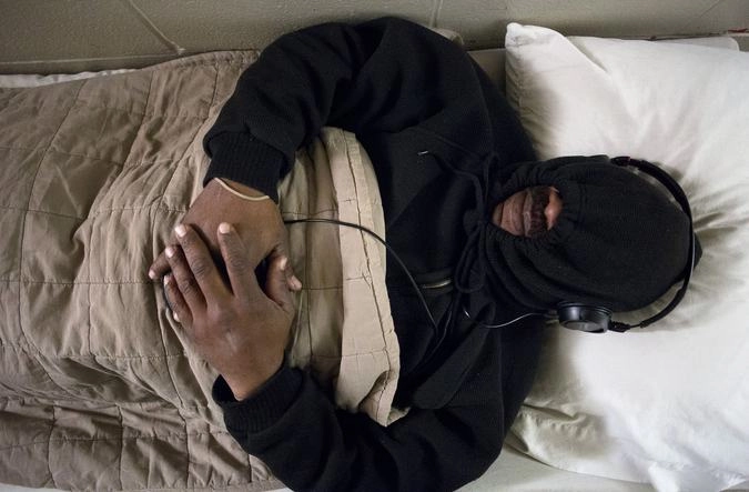 Мирон Джексон спит на раскладушке в коридоре приюта для бездомных. Атланта.