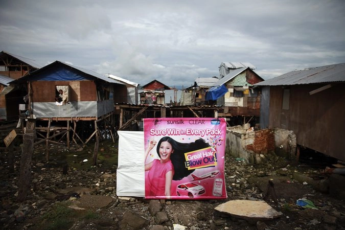 Плакат с рекламой шампуня для волос на фоне домов, которые были восстановлены после тайфуна.