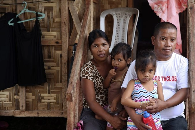 Ричард Паделия и его семья на пороге своего временного дома в Таклобане.