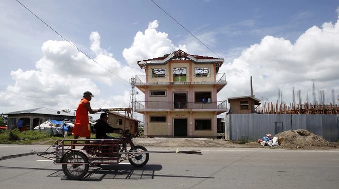 В Таклобане. Местные жители реконструируют пострадавший от тайфуна дом в центральной части города.