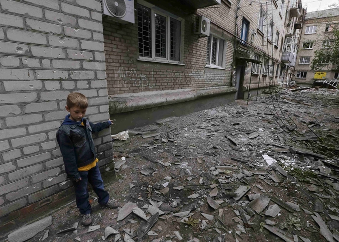 Мальчик играет в разрушенном дворе Славянска