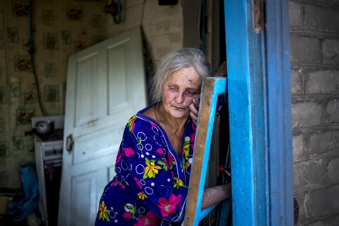 Местная жительница в своем доме, пострадавшем во время авиационного удара вооруженных сил Украины