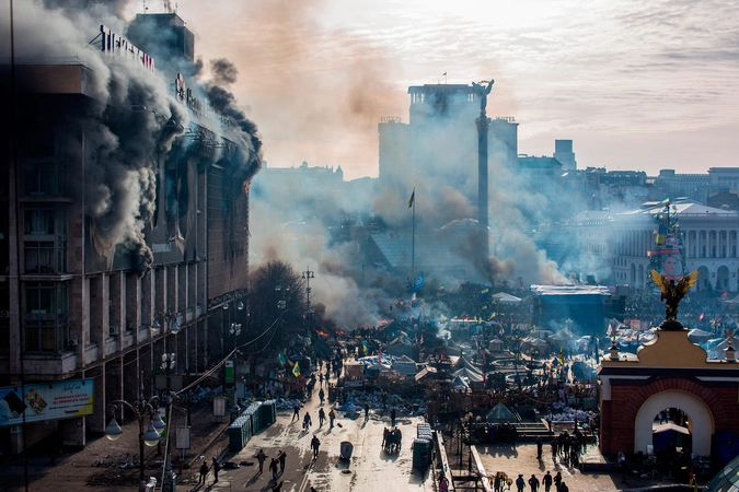Дым от пожаров и сторонники оппозиции на площади Независимости в Киеве, где начались столкновения митингующих и сотрудников милиции.