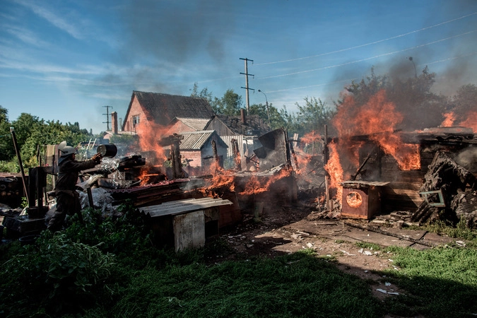 Последствия артобстрела Славянска украинскими военными. Пожарные пытаются тушить горящий дом.