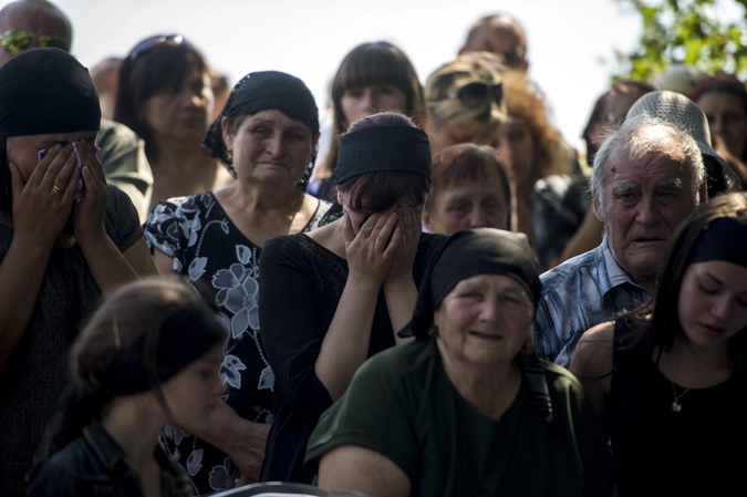 Родственники на похоронах погибшего ополченца в деревне Чернухино Луганской области.