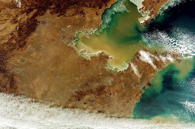 Река Хуанхэ, или "Желтая река" впадает в Желтое море, Китай. Темноватое пятно в центре, чуть повыше, — Пекин.