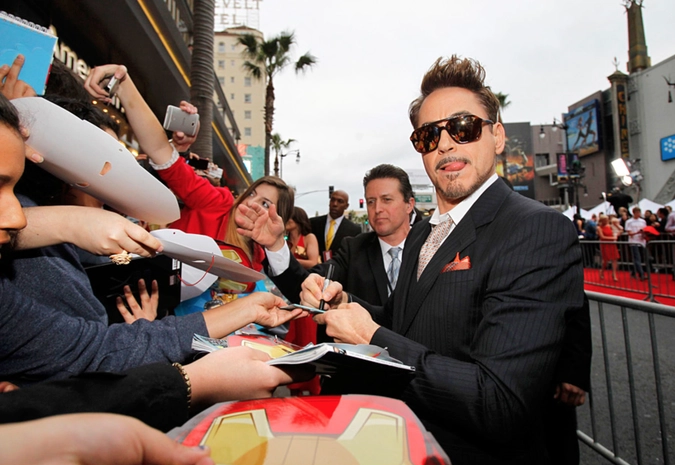 Роберт Дауни-младший раздает автографы на премьере фильма "Железный человек 3" в театре El Capitan в Голливуде.