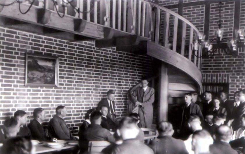 Собрание сотрудников группы Эйгена Зенгера (сам он стоит у лестницы, прислонившись к стене) в Научно-исследовательском институте техники ракетного полёта в Трауэне. 