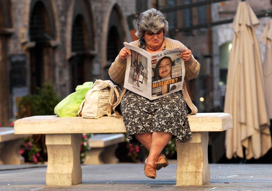 Женщина читает газету с заголовком Кто убил Мередит? © Alessandro Bianchi/Reuters