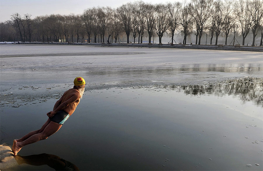 Пожилой китаец ныряет в ледяную воду озера в Шэньяне. © Reuters/Stringer