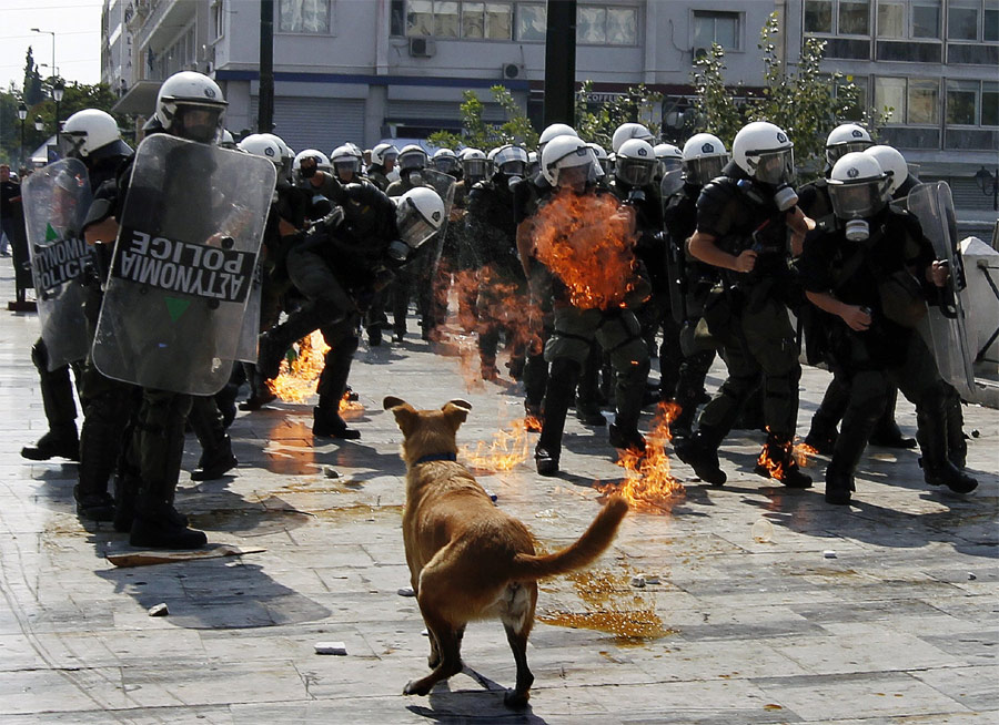 Афинские полицейские уворачиваются от коктейля Молотова во время разборки с демонстрантами на площади Конституции. Фото REUTERS/Yannis Behrakis
