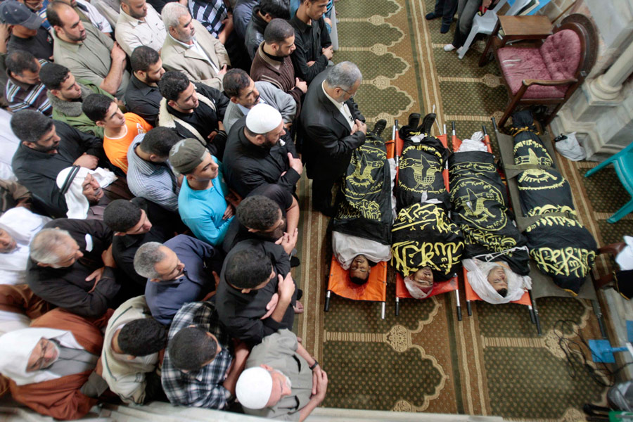 Палестинцы молятся над телами убитых моджахедов. © Ismail Zaydah/Reuters