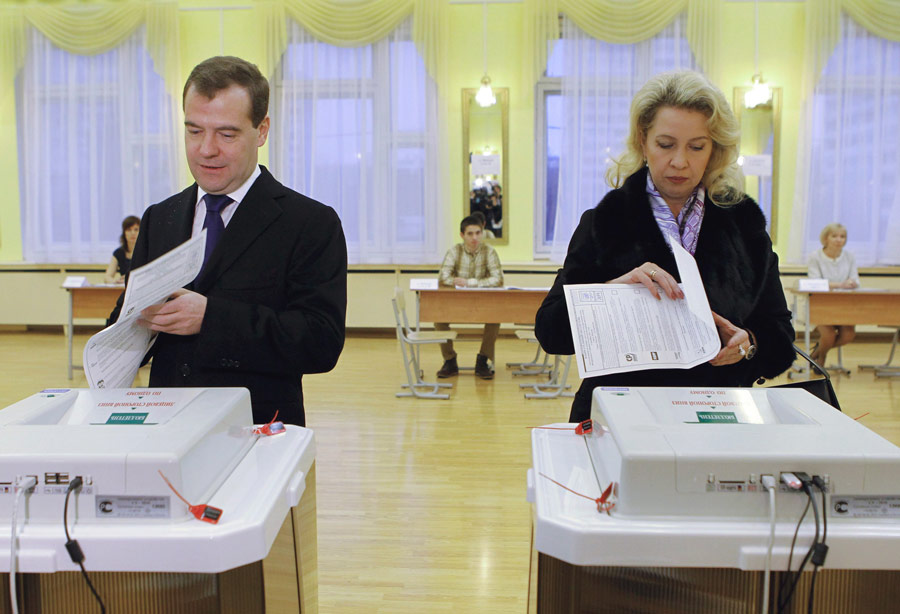 Президент Дмитрий Медведев (слева) со своей супругой Светланой Медведевой (справа) на избирательном участке. © Kremlin/RIA Novosti/Dmitry Astakhov/Reuters
