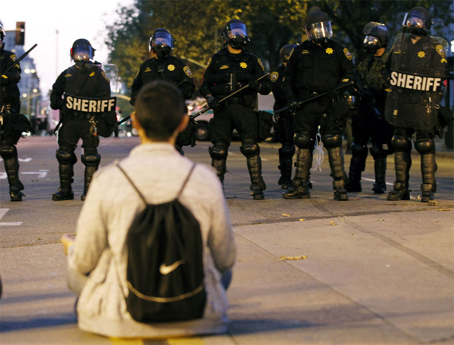 Участник демонстрации и полиция Окленда. © Kim White/Reuters