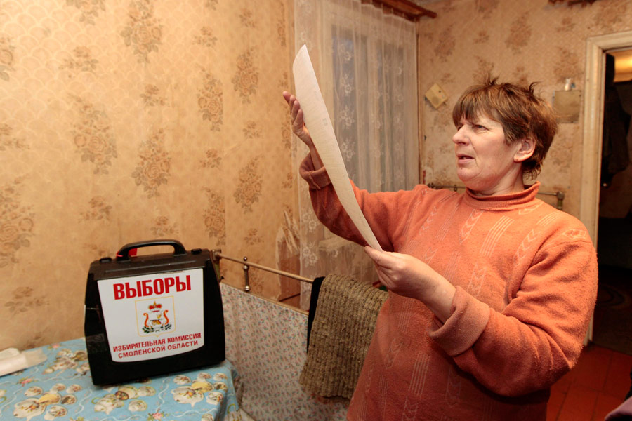 Женщина изучает бюллетень для голосования на дому в деревне Грязи. © Vasily Fedosenko/Reuters