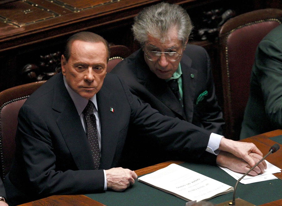 Берлускони за руку с лидером партии Северная лига Умберто Босси во время парламентского голосования, ставшего причиной отставки премьера. © TONY GENTILE/Reuters