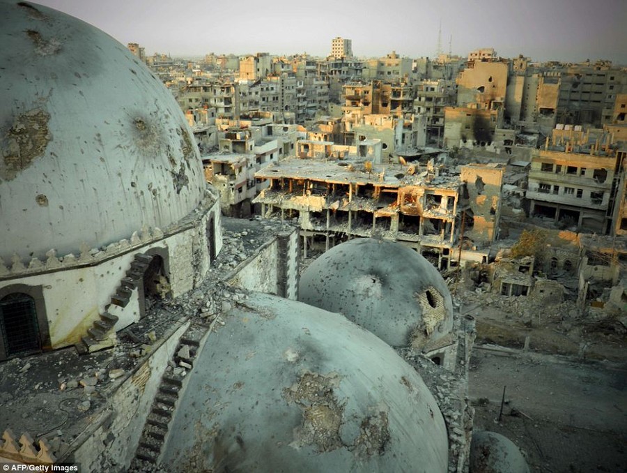 Shells of houses: The Khaled bin Walid Mosque is scarred and pockmarked from shrapnel spat into the city by the daily explosions that hit the city. Beyond the mosque, the shells of buildings and homes give the city the look of a post-apocalyptic wasteland