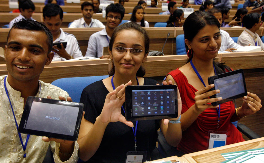Индийские студенты держат в руках планшет Aakash. © Parivartan Sharma/Reuters