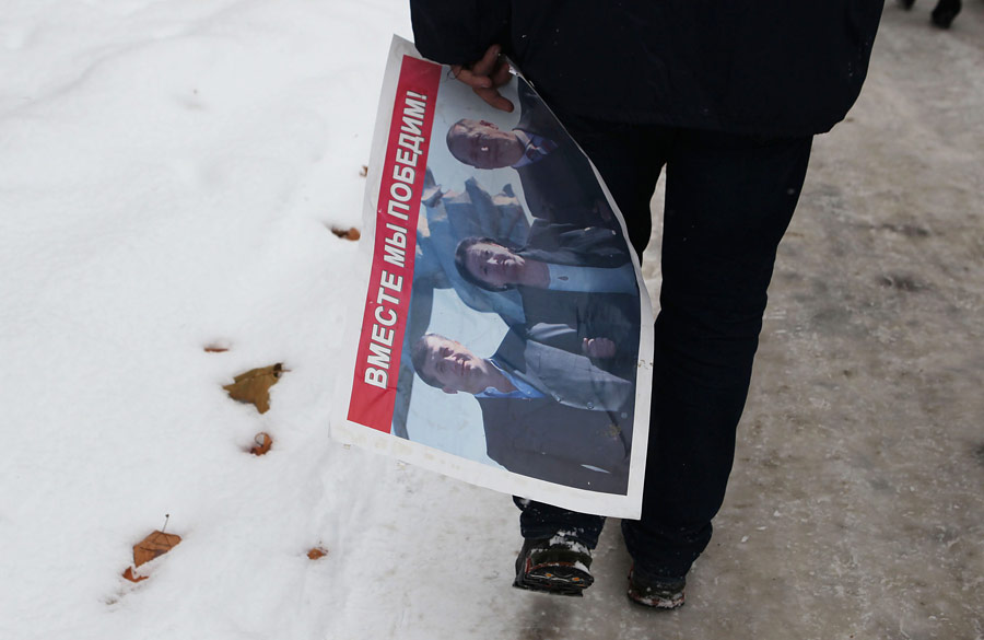 Агитплакат Аллы Джиоевой в руках ее сторонника. © Михаил Мокрушин/РИА Новости