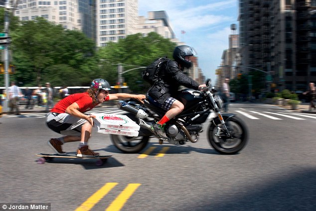 'Delivery Boy': Professional longboarder Adam Crigler takes delivering pizzas seriously as he catches a ride from a passing motorcycle in New York City 