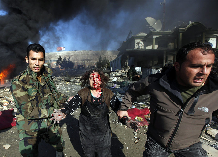 Пострадавшую от взрыва в Кабуле уводят с места происшествия. © Ahmad Masood/Reuters