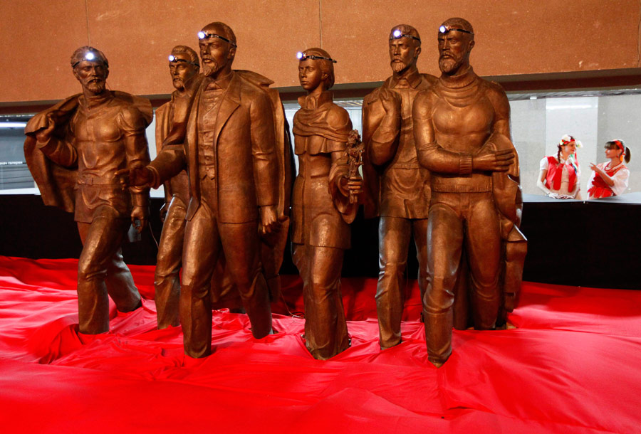 Скульптуры: женщина в традиционном русском костюме стоит рядом с вождем Советстого союза В.И. Ленина и его сподвижниками. © Ilya Naymushin/Reuters
