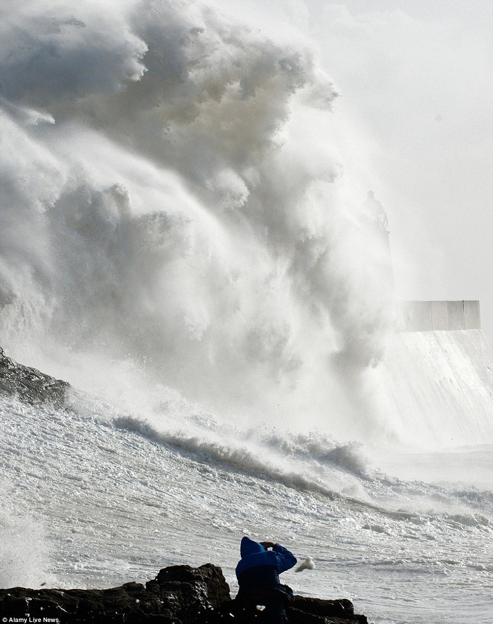 Capturing the moment: Photographers take a risk to get good shots of the storm waves at Porthcawl in Bridgend, South Wales