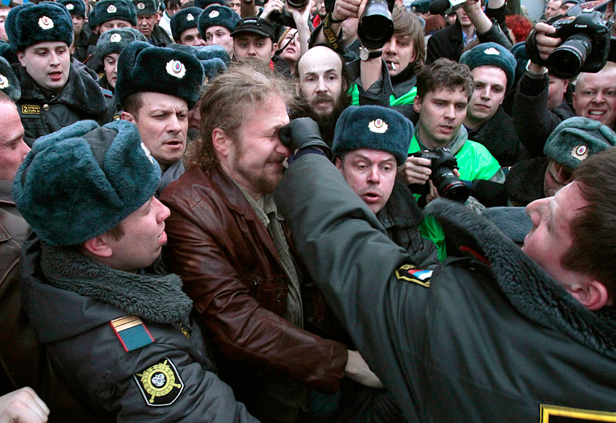 Сотрудник милиции бьет участника акции в защиту 31-й статьи Конституции 31 марта 2010 года. © Александр Натрускин/Reuters