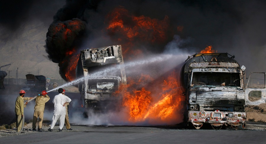 Пожарные пытаются потушить горящие бензовозы в пакистанском округе Мастунг. © REUTERS / Naseer Ahmed.