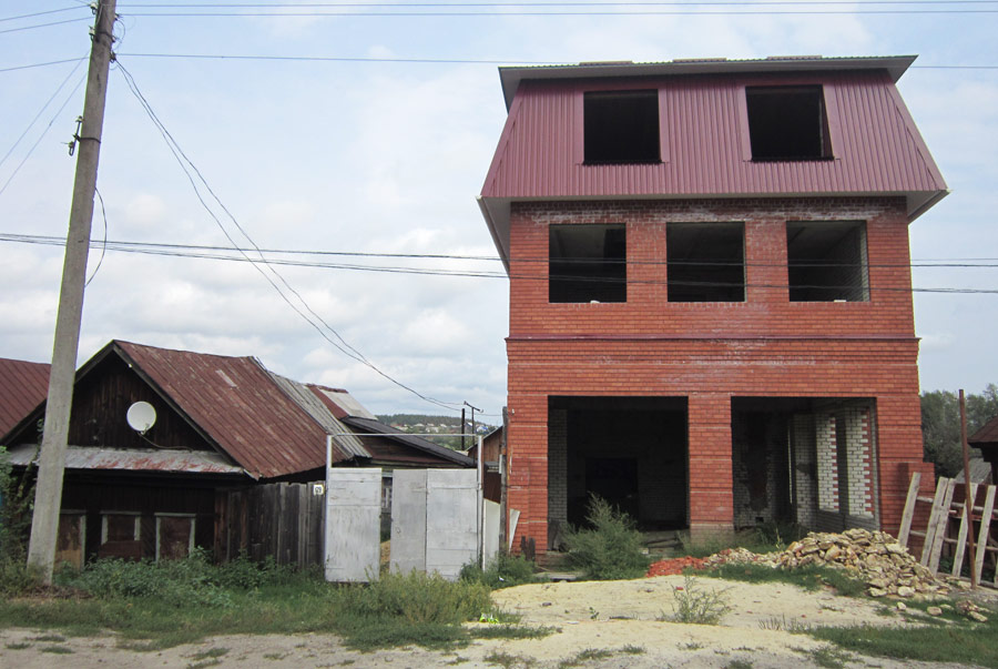 Строительство соседского трехэтажного кирпичного дома на границе территории дома семьи Степовых (дом Степовых слева).