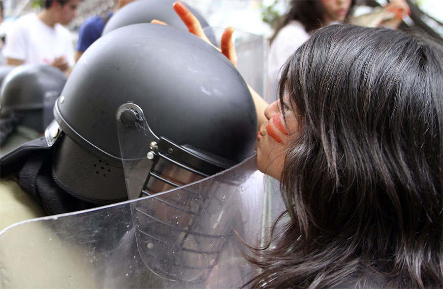 Колумбийская студентка целует полицейского во время многотысячной акции протеста против реформы высшего образования в Боготе. © John Vizcaino/Reuters