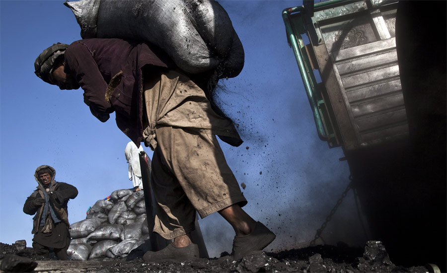 Афганец загружает уголь в грузовик на угольном складе неподалеку от Кабула. Многие рабочие приезжают сюда из северных провинций Афганистана, чтобы заработать большие деньги — 10 долларов в день. © Ahmad Masood/Reuters
