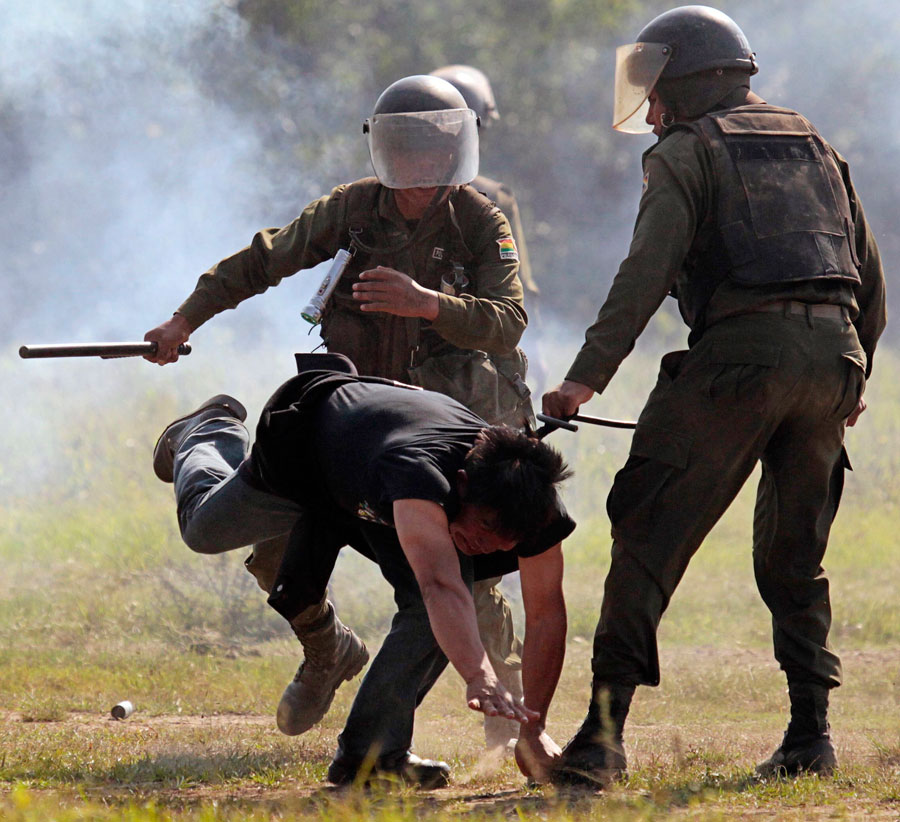 Полицейские избивают участника марша протеста. © David Mercado/Reuters