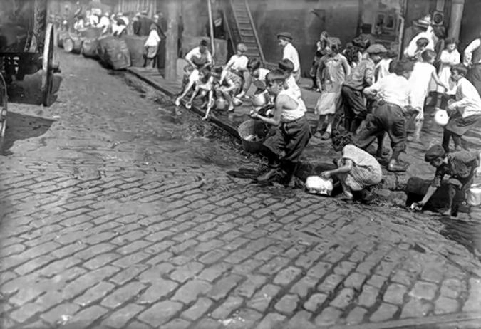 Дети собирают текущее по улице вино, которое было вылито агентами Bureau of Prohibition. Это, кстати, было еще одной причиной, по которой перестали сливать конфискат на землю прямо на месте.