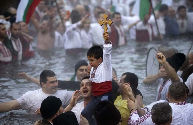 Мальчик держит деревянный крест, который был брошен священником.  