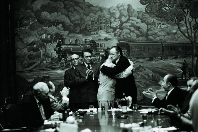 Ричард Конте в роли Дона Эмилио Барзини следит за прекращением военных действий между Доном Филиппом Таттиглой (Виктор Рендина) и Доном Вито Корлеоне (Марлон Брандо)