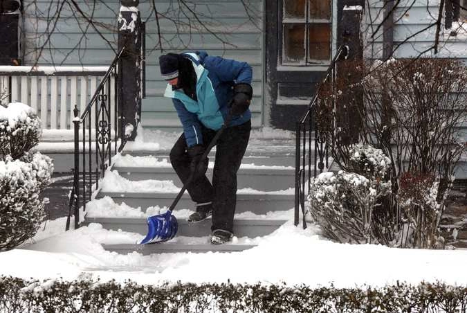 Житель поселка Элмвуд  чистит снег.  Буффало. © Don Heupel /Reuters