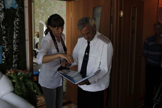 Иван Андрухович лучший участковый России показывает журналистам книгу почета.