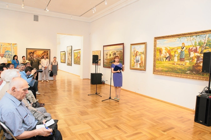 Генеральный директор Музея современной истории Ирина Великанова выступает с приветственной речью на фоне работ татарских художников, проживающих в Москве.