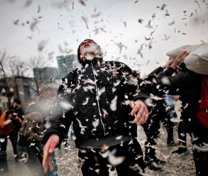 Молодые люди проводят флэш-моб "Бой подушками" в Москве на Цветном бульваре. 02.04.2011