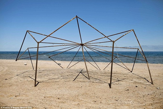 Сооружение из палок для зонтиков на заброшенном пляже.