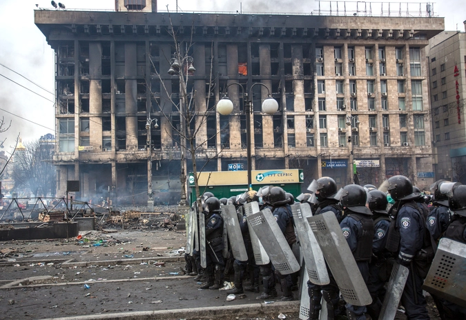Сотрудники правоохранительных органов у сгоревшего Дома профсоюзов на площади Независимости в Киеве, где происходят столкновения митингующих и сотрудников милиции.