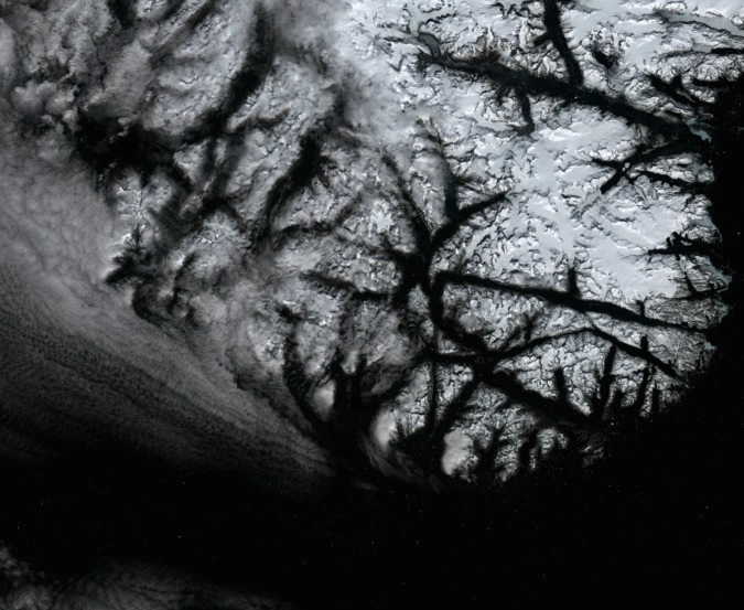 А это самый большой остров на нашей планете — Гренландия. Белые точки внизу — айсберги.