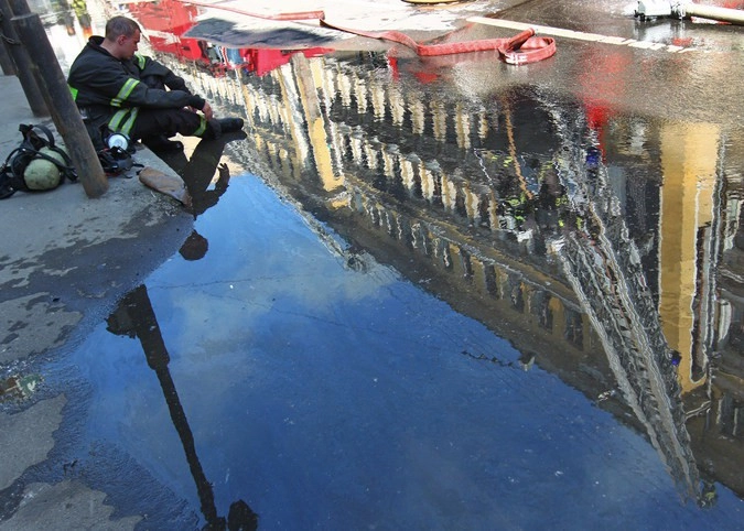 Сотрудник пожарной охраны МЧС РФ у здания на Садовнической набережной, где произошел пожар. 07.06.2011