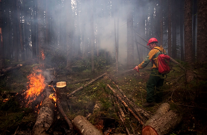 Сотрудник Авиалесоохраны Красноярского края во время тушения пожара в селе Турка Прибайкальского района Республики Бурятия.