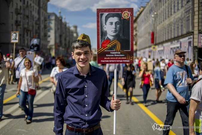 Парнишка несет фотографию деда, старшего лейтенанта 63 артиллеристской дивизии. Воевал с первых дней войны, закончил - в сентябре 1945 в Манчжурии