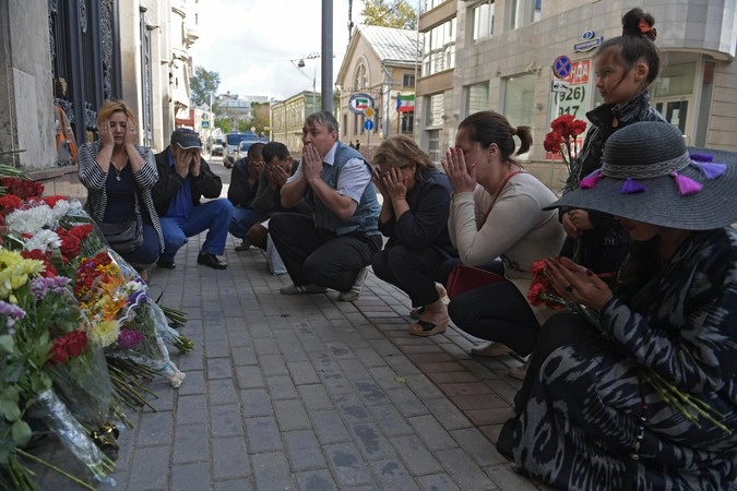 Мужчины и женщины молятся у посольства Узбекистана в Москве. 