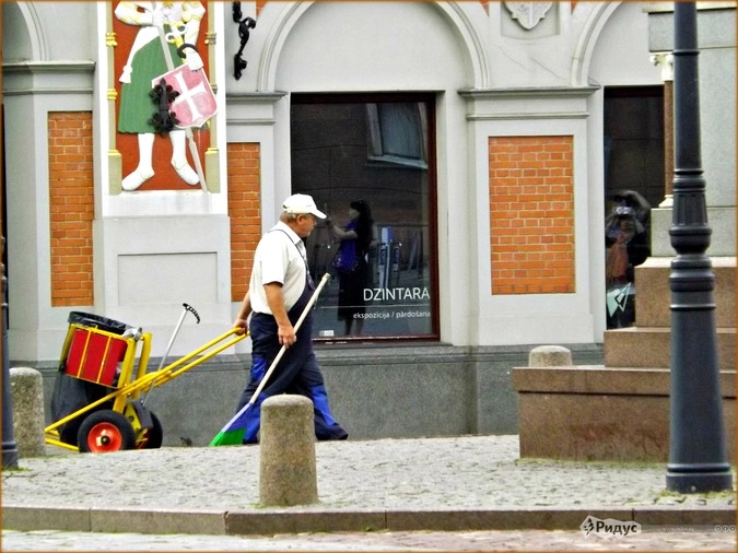 Дворник убирает за туристами старый город 
